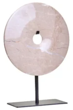 a modern and minimalistic round cream marble disc sculpture on black metal stand