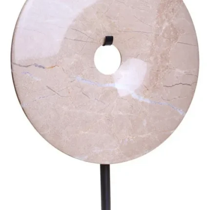 a modern and minimalistic round cream marble disc sculpture on black metal stand