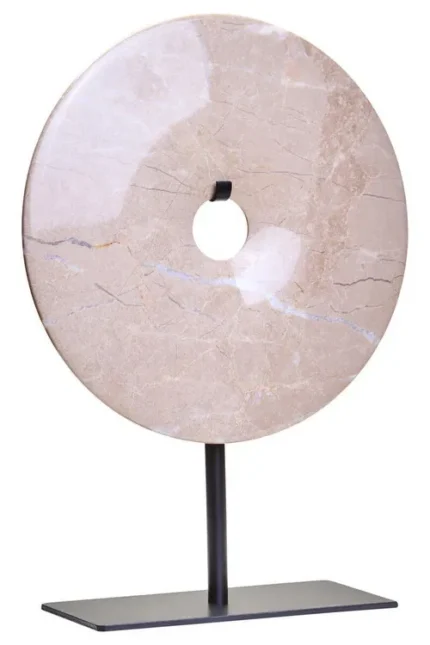 a modern and minimalistic round cream marble disc sculpture on black metal stand