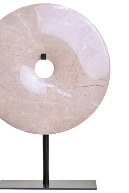 a modern and minimalistic round cream marble disc sculpture on black metal stand front view