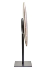 a modern and minimalistic round cream marble disc sculpture on black metal stand side view